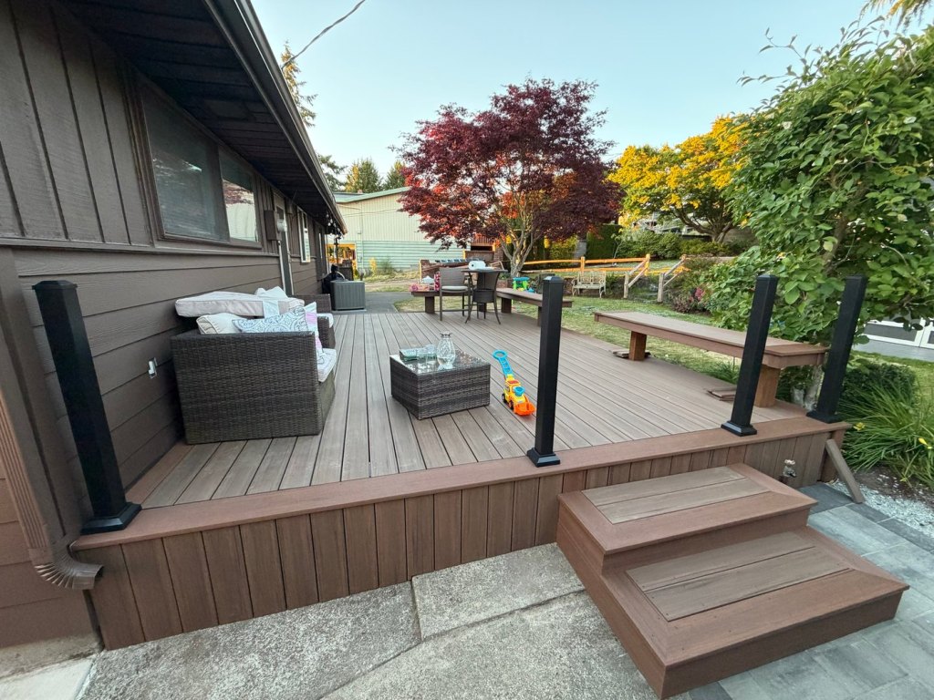 The finished deck in the early evening with outdoor furniture in place and the bench running along the far edge.