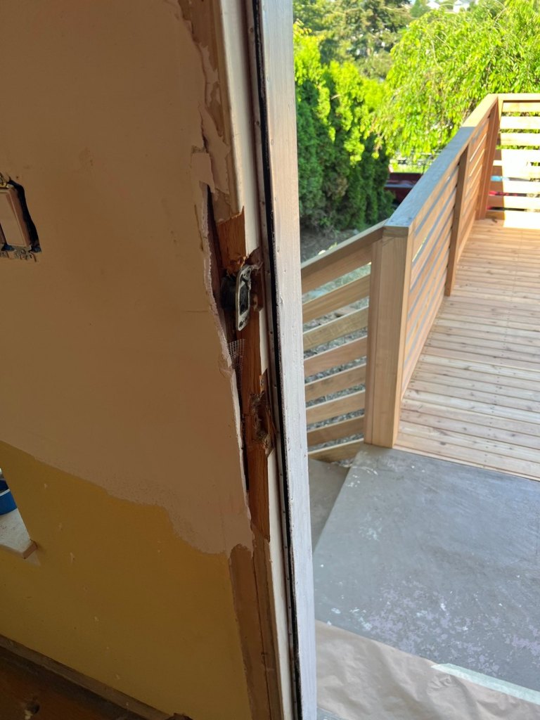 The finished cedar deck seen from a doorway, with horizontal cedar slats under a wide flat top rail.