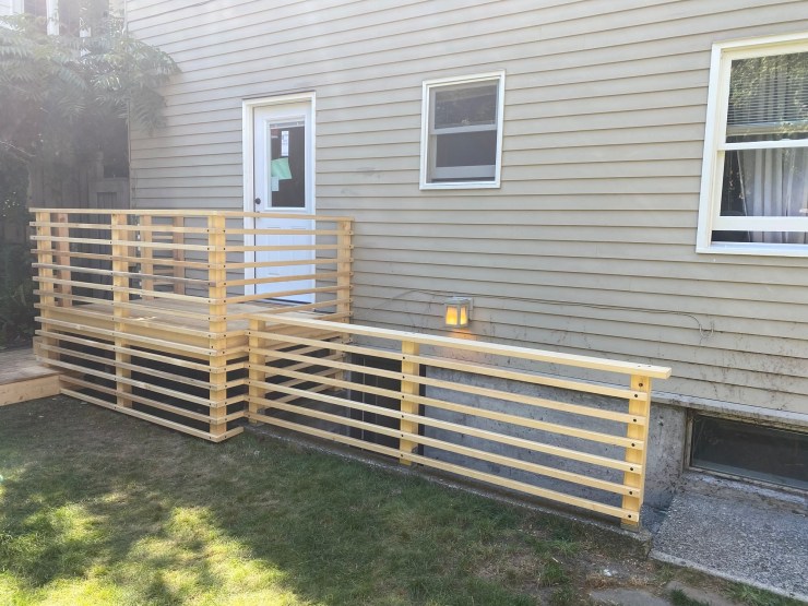 The finished West Seattle deck railing, horizontal cedar slats wrapping the perimeter