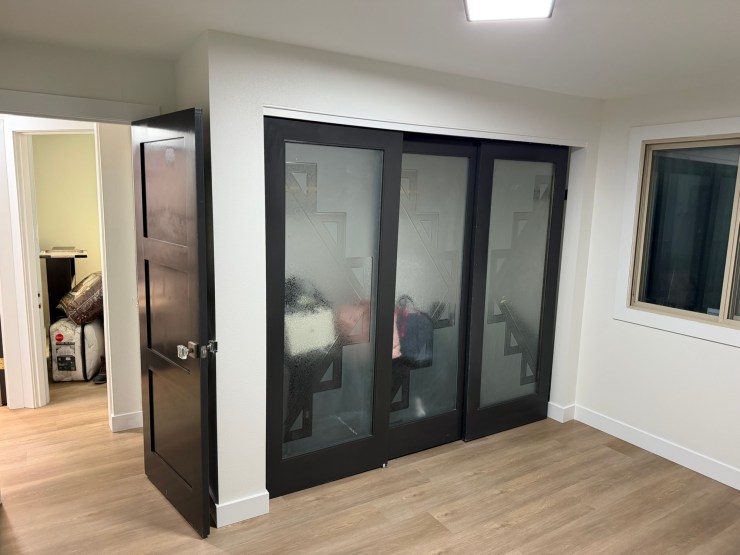 Built-in glass-door closet added for enlarged closet space in the Burien remodel