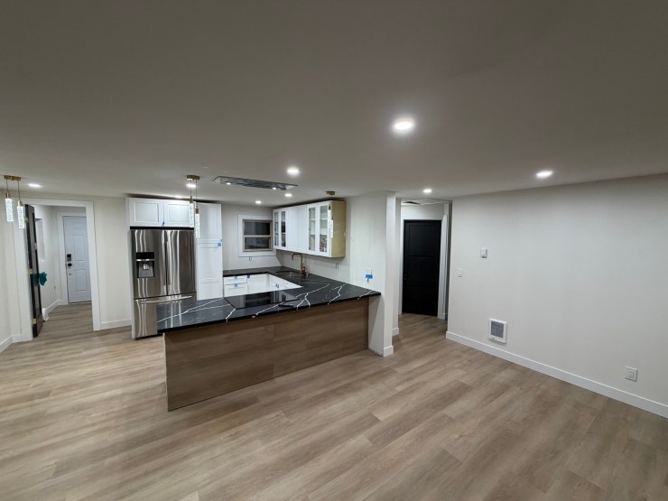 Finished Burien kitchen and living room, wide angle showing the full open-concept layout