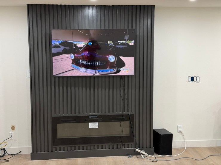 Close view of the fireplace and mounted TV on the new fluted accent wall in the Burien great room