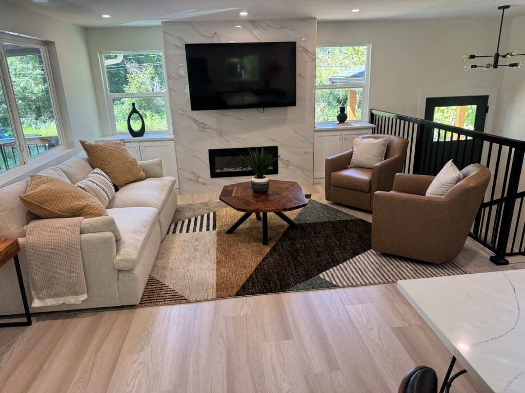 Wide view of the main floor living room with the rebuilt fireplace and porcelain tile accent wall