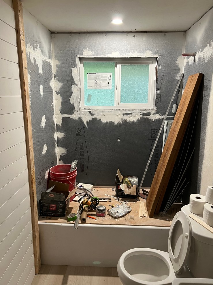 Shiplap walls and the bathtub during the rough-in stage of the second bathroom remodel
