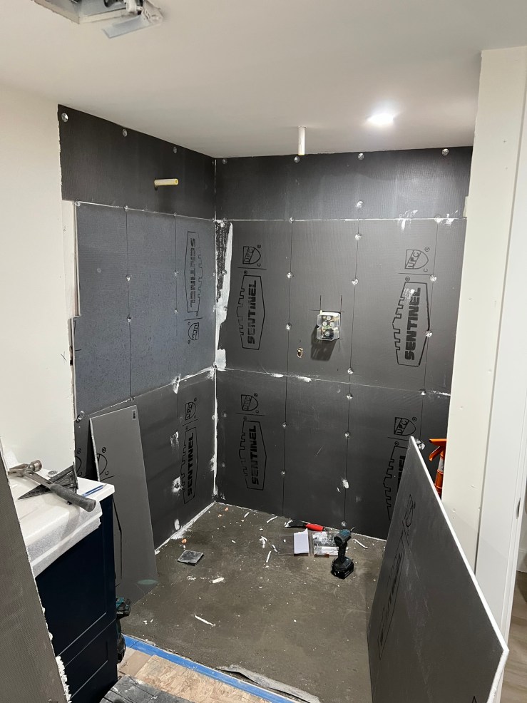 Waterproofing membrane applied to the shower walls in the primary bathroom