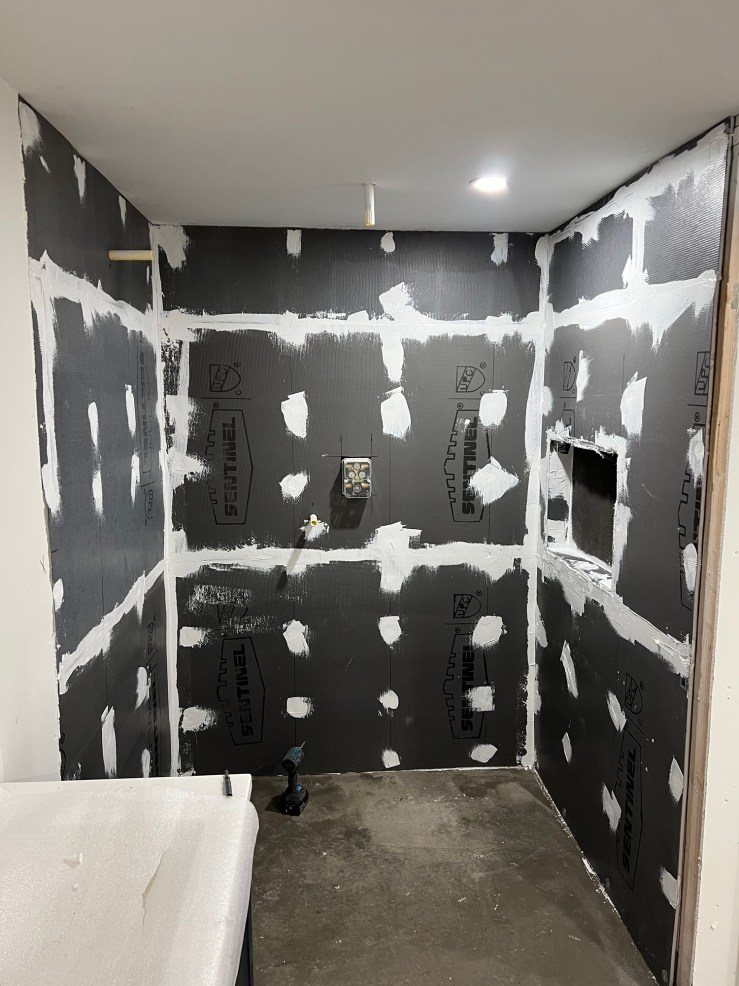 Waterproofing membrane taped and sealed, with the shower valve cutout, in the primary bathroom