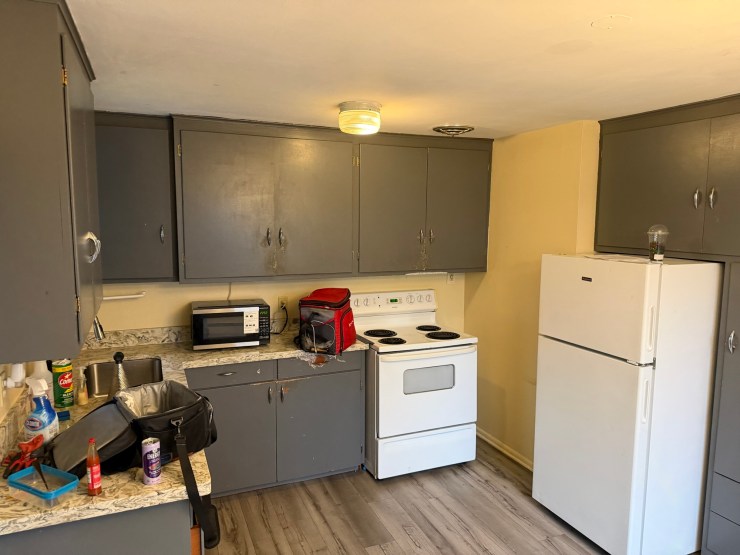 The original Burien kitchen before the remodel, dated gray cabinets and a white range
