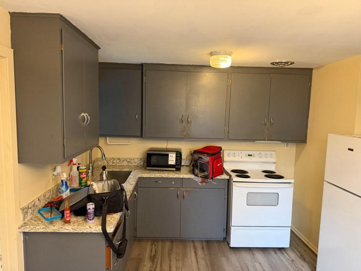 Another view of the original Burien kitchen before the remodel, gray cabinetry and yellowed walls