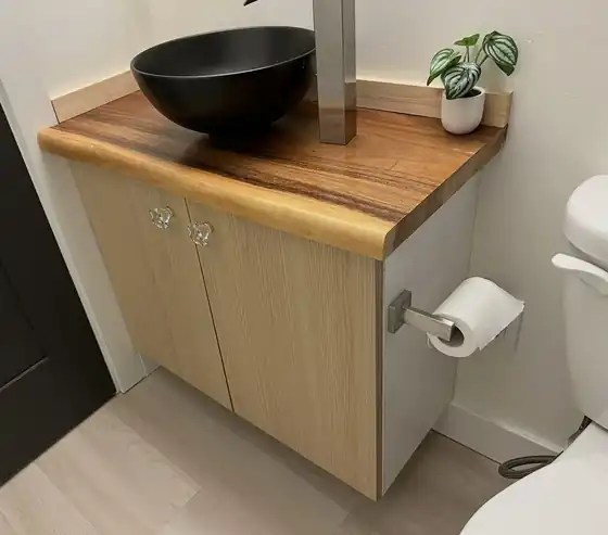 Wall-hung vanity with a solid wood top and a black vessel sink