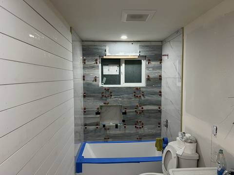 Tacoma bathroom tub and shower wall in tile backer board and waterproofing, before tile, with white shiplap and a toilet in the foreground