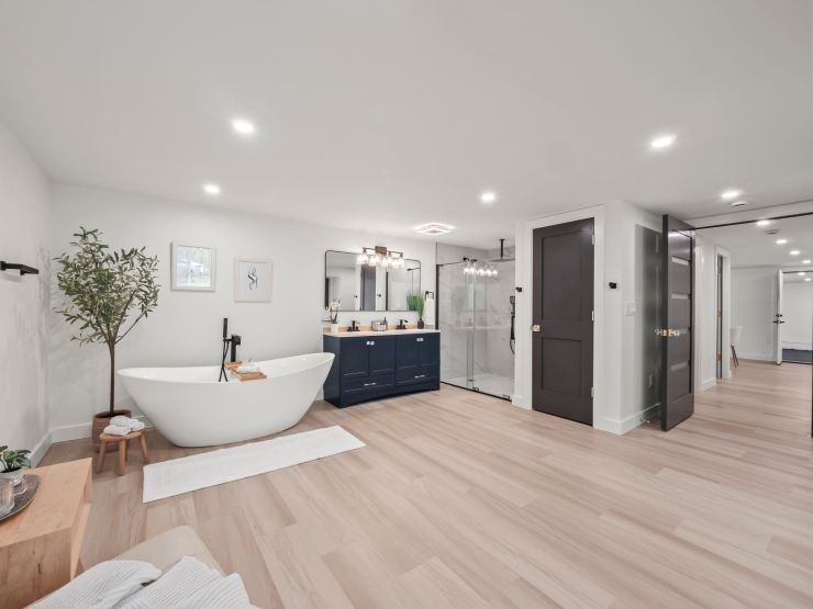 A third Tacoma bathroom: a freestanding tub, navy double vanity and a glass-enclosed shower